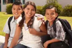 Three children posing outdoors together