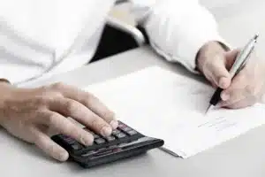 Person using calculator and writing