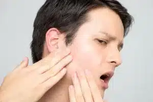 Person touching their face gently