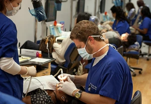 Dentist conducting thorough dental examination on a female patient, using precision tools. 