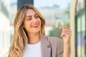 Woman holding Invisalign clear aligner