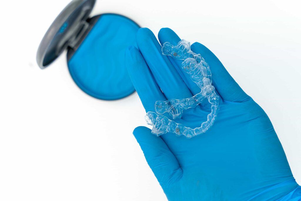 Does Medi-Cal Cover Invisalign in California? 6 hand with glove holding invisalign