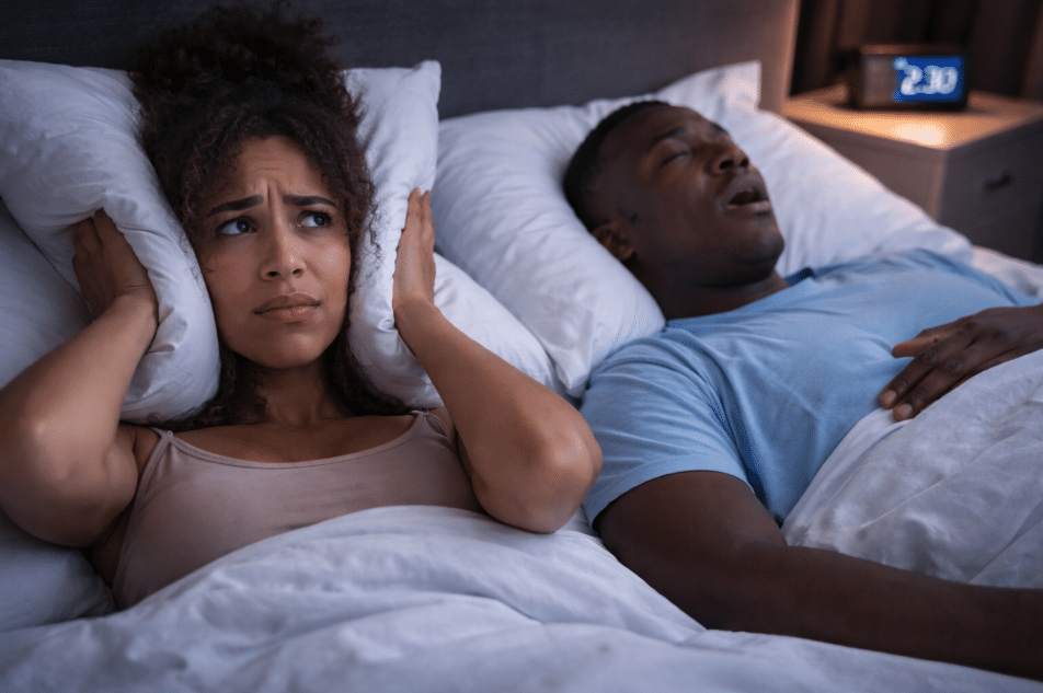 Screenshot 2026-01-27 at 11.23.55 AM Couple in bed, covering ears.