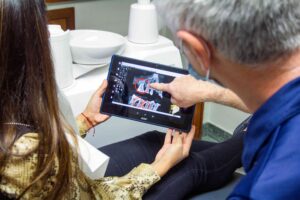 Patient reviewing dental images on tablet.