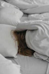 WOMAN SLEEPING BLANKETS COVERING FACE AND HEAD